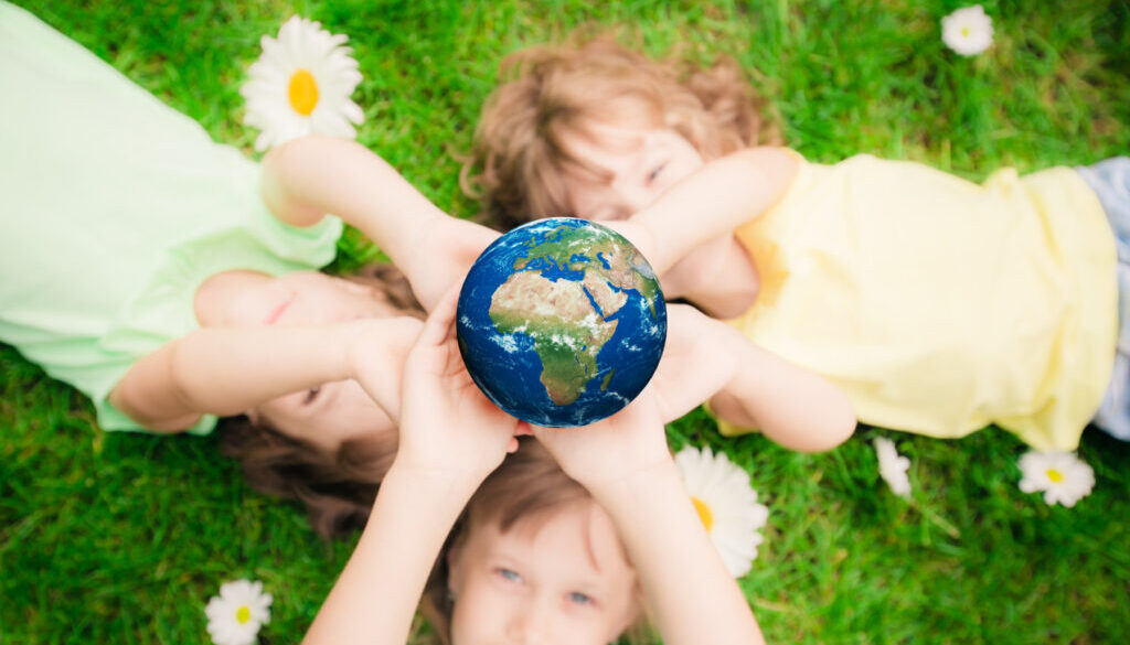 Children,Holding,3d,Planet,In,Hands,Against,Green,Spring,Background.